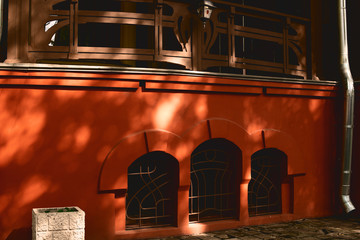 Facade of the historic building yellow-orange building with window arches. Sunset light