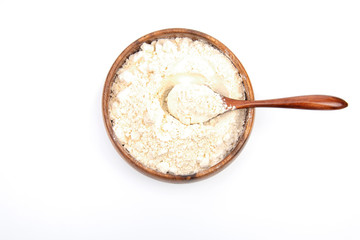 Wheat flour in bowl or wooden plate white background. Top view.