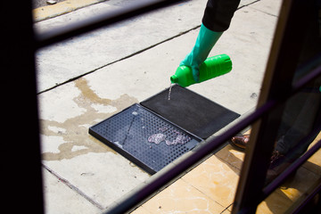 Hands with gloves putting alcohol on a mat