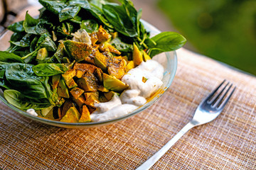 Сhick peas salad bowl with tomatoes, fresh green basil leaves and avocado. Brown background.Closeup view