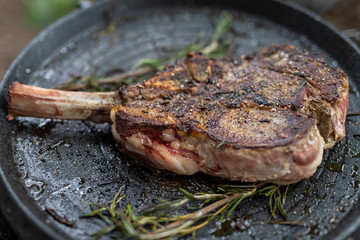 tomahawk steak on grilling pan with rosemary