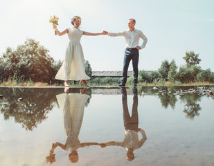 Dancing bride and groom are reflected in the water