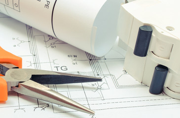 Electrical diagrams, electric fuse and pliers on construction drawing of house. Building home