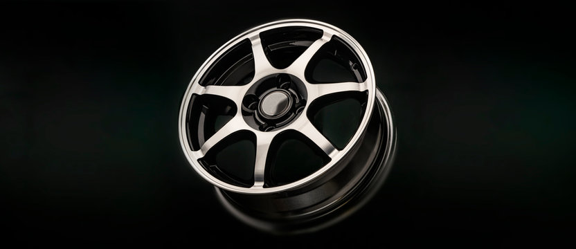 Shiny sporty lightweight Alloy wheel on a dark background. panoramic photo