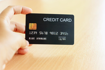 Shopping and payment concept. Close up of women hand holding black credit card. Shopping online with credit card.