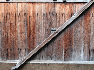 The old wooden door was closed using a timber across it.