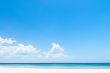 Tropical island white sand beach with blue sky and clouds in summer, tranquil serene blue ocean scenery