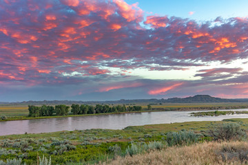 Sunrise and clouds over the Yellowstone River at the confluence with the Powder River near Terry, Montana, USA - obrazy, fototapety, plakaty