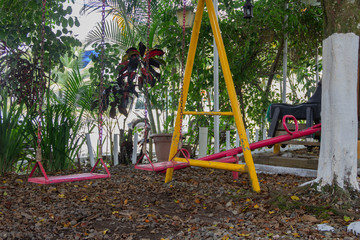 Juegos infantiles en jardín entre columpios y caballito