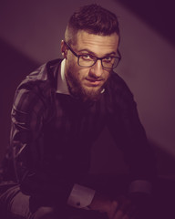 Obraz premium Portrait of young successful caucasian man wearing glasses. image toned in warm colors in retro style