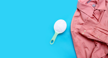 Shirt with detergent powder on blue background.