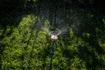 Universal garden sprinkler on a green lawn with a water fountain