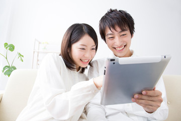 タブレットPCを見る夫婦 © Paylessimages