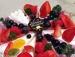 Happy Birthday Berry cakes were served at the Happy birthday anniversary party. Close up image of sweet and colorful dessert. HBD berry fruit cake collection. Fruit and dessert concept.