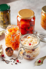 Fermented preserved vegetables food concept. Glass jars with fermented, pickled and canned vegetables  on  kitchen table. Conservation of farm organic seasonal harvest. Healthy homemade food