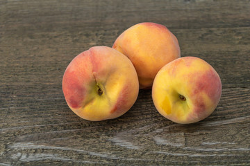 Naklejka na ściany i meble Juicy and delicious peaches on a wooden background