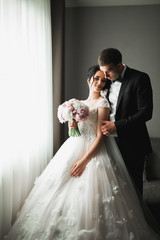 Naklejka premium Wedding couple on the nature is hugging each other. Beautiful model girl in white dress. Man in suit
