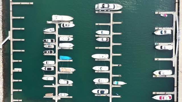 Vista a&eacute;rea sobre una marina con algunos yates de diferentes tam&ntilde;os atracados y sin moverse