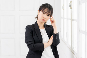 考えるジェスチャーをする若い女性
