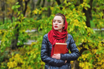 Portrait of a young beautiful girl in an autumn city Park