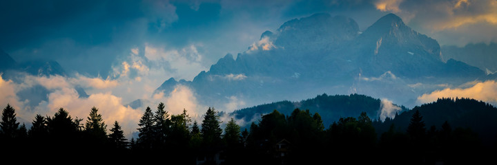 Berge mit Wolken im Sonnenuntergang - Panorama mit Alpspitze und Zugspitze am Abend