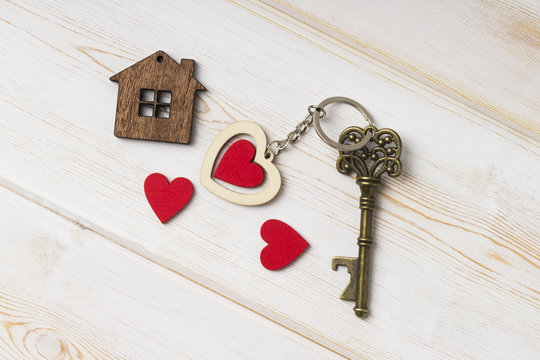  House Key With Home Keyring Decorated With Wooden  Heart.  Old Key With A Heart On White Wood . Sweet Home Concept .