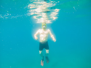 Fototapeta na wymiar man swimming underwater with snorkeling musk