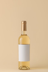 Bottle of wine with blank label on color background. Mockup for design