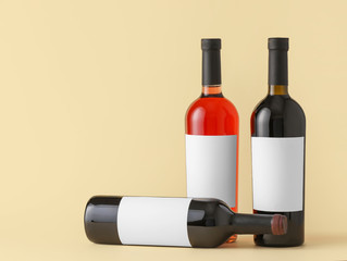Bottles of wine with blank labels on color background. Mockup for design