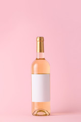 Bottle of wine with blank label on color background. Mockup for design
