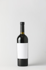 Bottle of wine with blank label on light background. Mockup for design