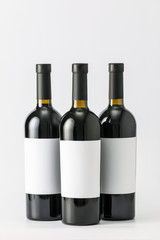 Bottles of wine with blank labels on light background. Mockup for design