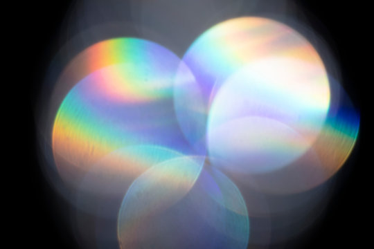 Lens flare, Bokeh lights. Reflections from glass, diamond, crystal. Defocused shining colorful rainbow light leaks, rays on black background
