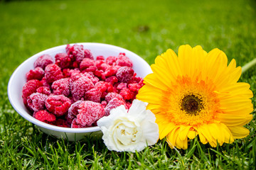Frambuesas y flores frescas al natural
