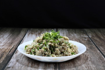 Traditional spicy chopped fish meat salad with chilly and coriander seasoning with lime juice and sugar syrup on the plate. Famous street food menu in Thailand.