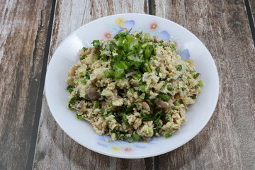 Traditional spicy chopped fish meat salad with chilly and coriander seasoning with lime juice and sugar syrup on the plate. Famous street food menu in Thailand.
