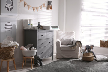 Chest of drawers with changing tray and pad in baby room. Interior design