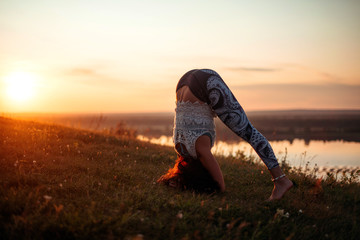 Yoga practice and meditation in nature in sunrise. Woman practicing near big river Kama.