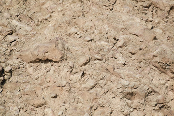 Rocky hill. Light beige abstract textured background. Surface. Terrain gravel wall. Cracked rock stones. Copy space