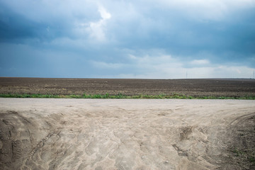 Landscape consisting of a plowed field road and sky. Belarusian rural landscape