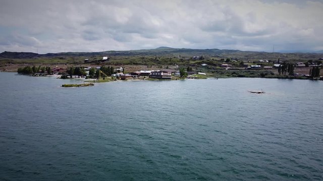 Drone Flying forward (zooming in) to the Coastline with the Hotel Building and beautiful mountains at the background