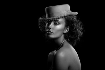 Black and white portrait of a young woman in a hat with a veil. Vintage style. Beautiful lady.