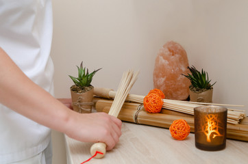 
Close-up of the hands of the masseur holding bamboo sticks. Spa, wellness concept on bamboo...