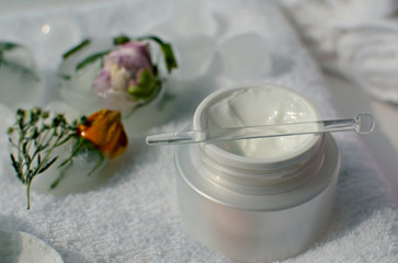 cream, ice cubes and white cotton towels, spa accessories for skin care