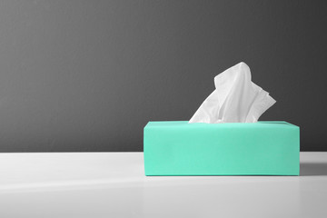 Box with paper tissues on white table. Space for text