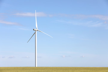 Beautiful view of field with wind turbine. Alternative energy source