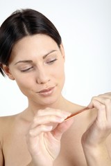 Woman filing her fingernail