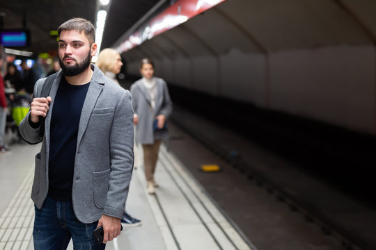 Confident man awaits train at subway station. High quality photo