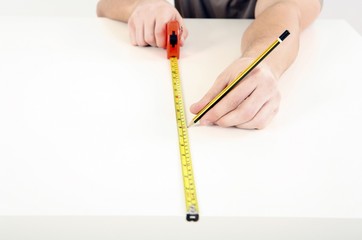 Man using tape measure on wooden board
