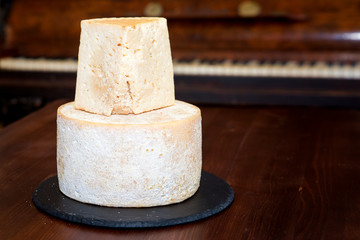 Cheese, a head of hard cheese on a brown background. close-up